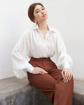 Wide-leg silk pants with high-rise waist and tailored pleats for effortless sophistication